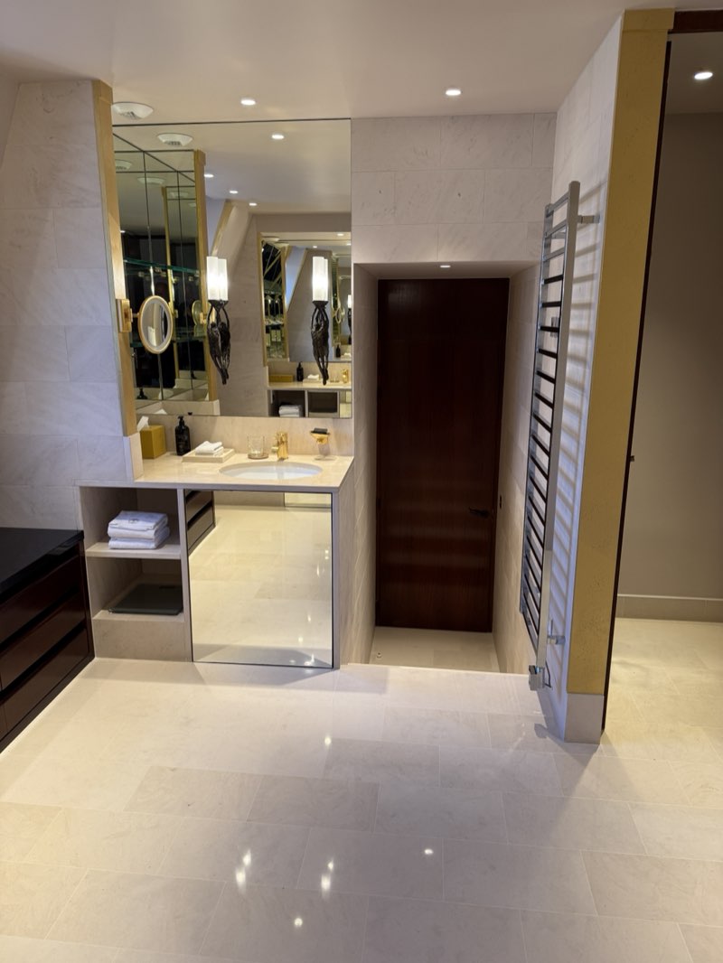 Walk-through marble bathroom at the Park Hyatt Paris-Vendôme with a heated towel rack and wood wardrobe